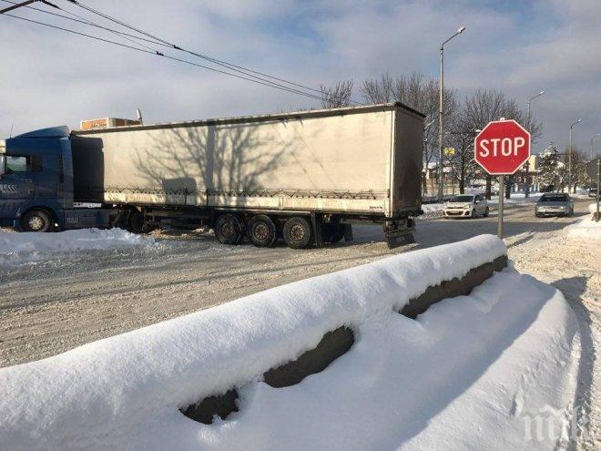 СНЕЖЕН АД! ТИР затапи възлов булевард във Враца, двама с лопати копаят да го измъкнат (СНИМКИ)