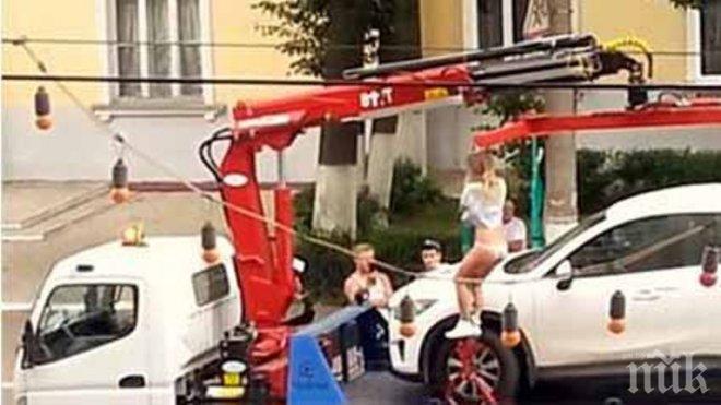 Секси мадама направи стриптийз, за да отърве колата си от паяк (видео)