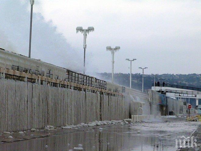 Морските вълни замръзват по крайбрежните камъни