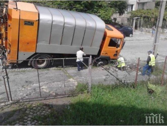 Шок! Дупка на пътя глътна боклукчийски камион (снимки)