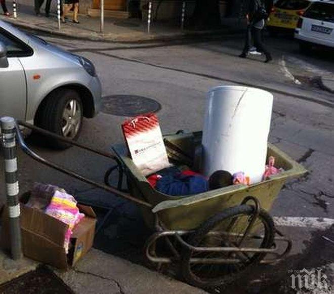 Безобразие в центъра на София! Дете спи в количка с боклуци, докато родителите му си пият бирата!