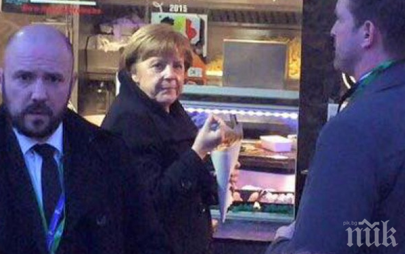 Ангела Меркел си похапва пържени картофки на крак (снимка)