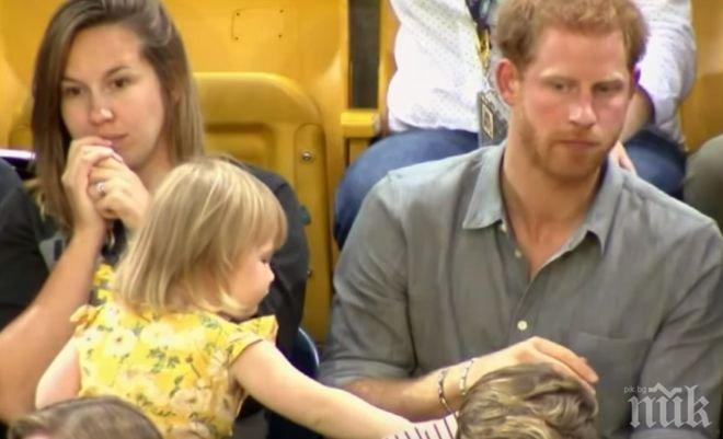 УМИЛИТЕЛНО! Малко момиченце си хапва от пуканките на принц Хари по време на мач (ВИДЕО)