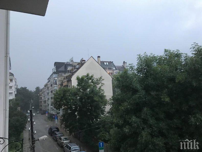 ИЗВЪНРЕДНО В ПИК! Дъжд се изля като из ведро в центъра на София, гърмя и трещя