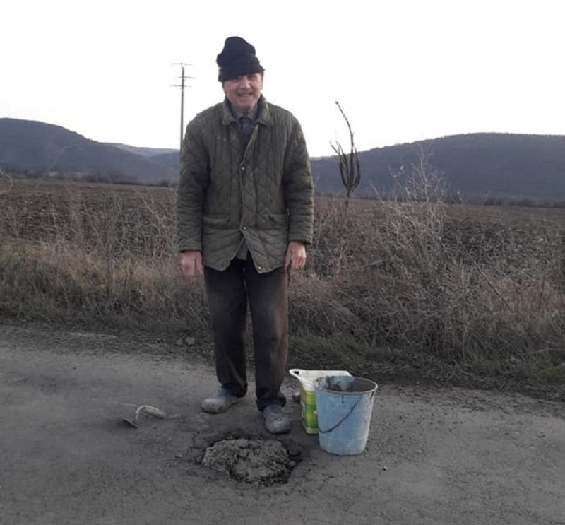 Пенсионер запълва сам зинали дупки по пътя