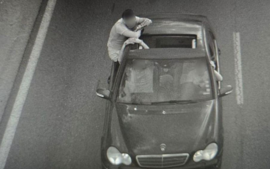 Тол камери уловиха опасно поведение: Пътник седнал на прозореца на движеща се кола