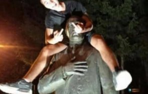 хулиган момче яхна паметника банкера буров размахва средни пръсти