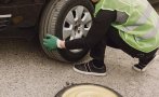Кола премаза крака на мъж, докато сменял гума